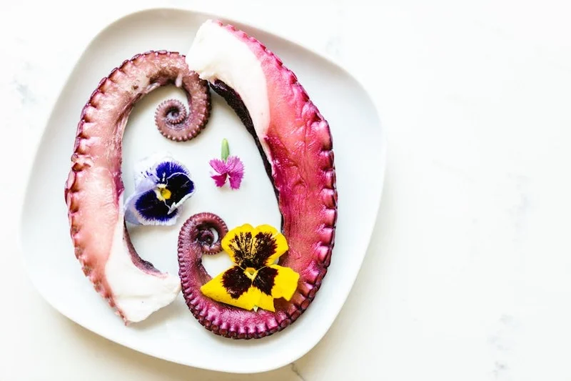 Exquisito plato de mariscos con percebes y flores comestibles, presentación de alta cocina