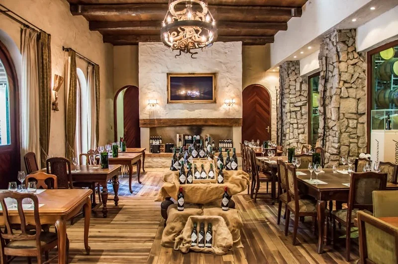 Interior acogedor de un restaurante español tradicional con paredes de piedra y vigas de madera