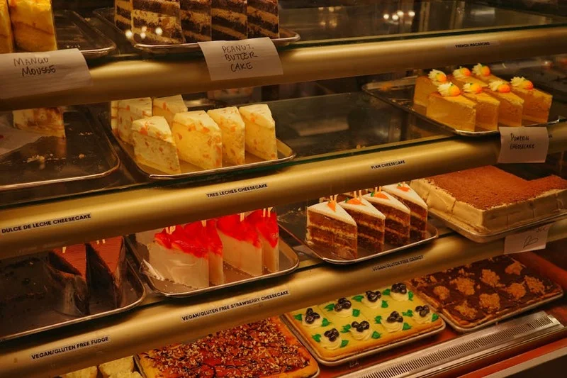 Una hermosa exhibición de varios postres, incluyendo tartas de frutas, pasteles de chocolate y cheesecakes cremosos