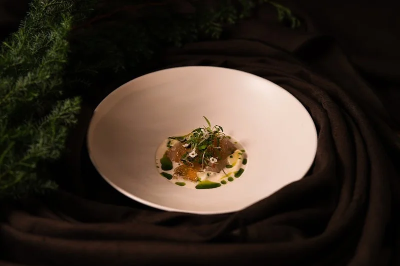 Pareja elegante cenando en un restaurante con estrella Michelin, enfoque en la presentación