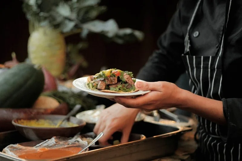 Chef presentando un plato con vegetales frescos y de origen local, concepto de la granja a la mesa