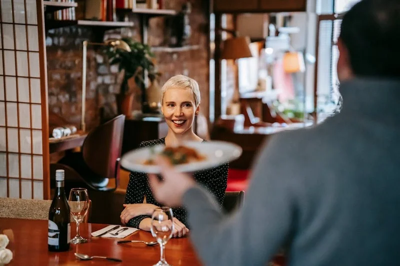 Un camarero sirviendo una copa de vino tinto en un restaurante español